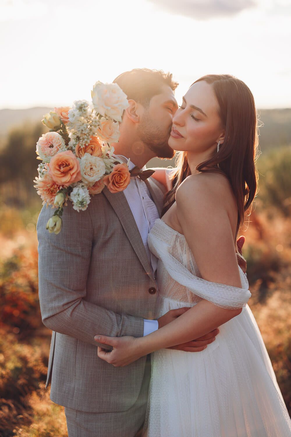 Bräutigam küsst die Braut sanft im goldenen Sonnenlicht bei einem emotionalen Hochzeitsshooting in Braunschweig und Hannover