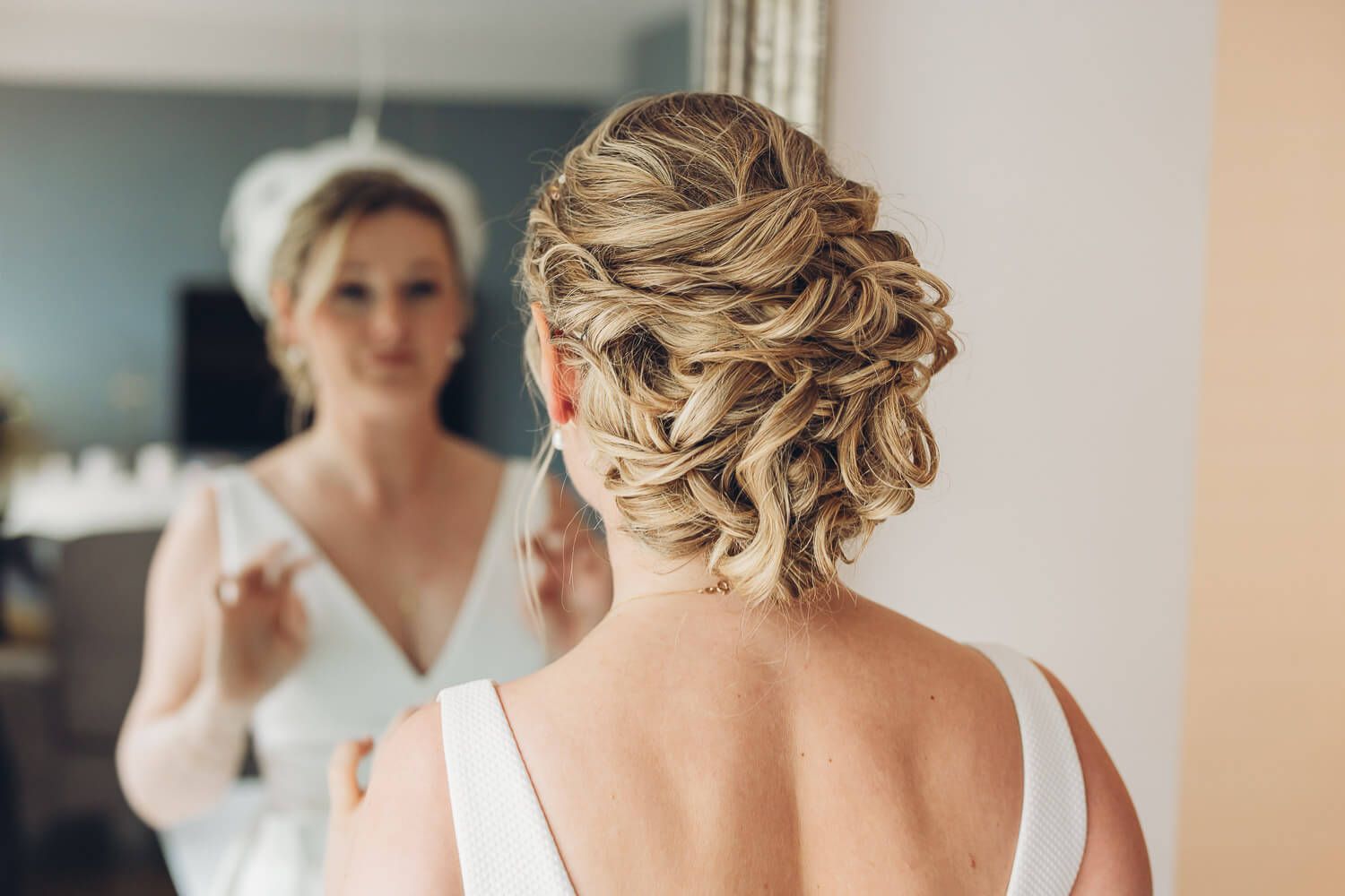 Elegante Brautfrisur von hinten im Spiegel fotografiert bei einer Hochzeit in Braunschweig durch eine Fotografin
