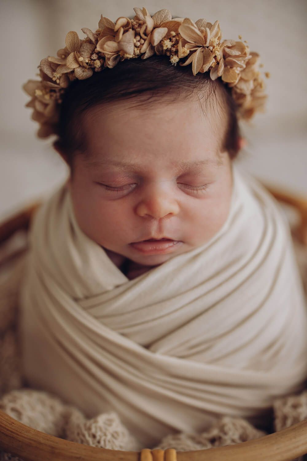 Detailaufnahme eines schlafenden Neugeborenen mit zartem Blumenkranz bei einem Newborn Shooting in Hildesheim