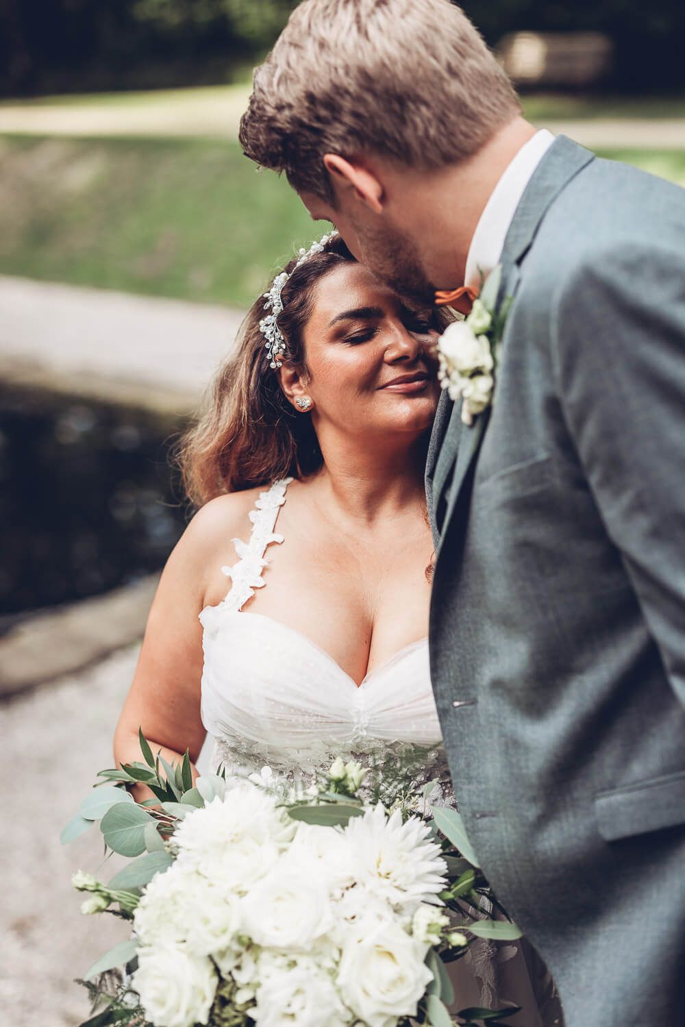 Inniger Moment beim Brautpaarshooting, während der Bräutigam die Braut liebevoll küsst, fotografiert von einer Fotografin in Hannover