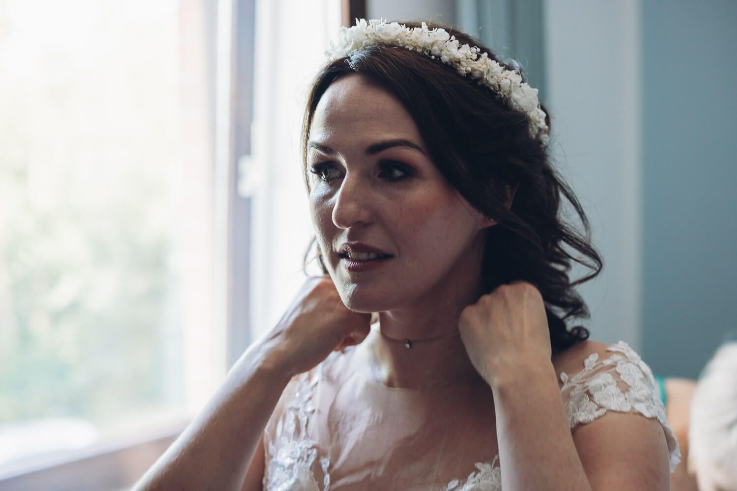 Braut legt beim Getting Ready vor ihrer freien Trauung in Hannover ihren Schmuck an, emotional begleitet von einer Hochzeitsfotografin