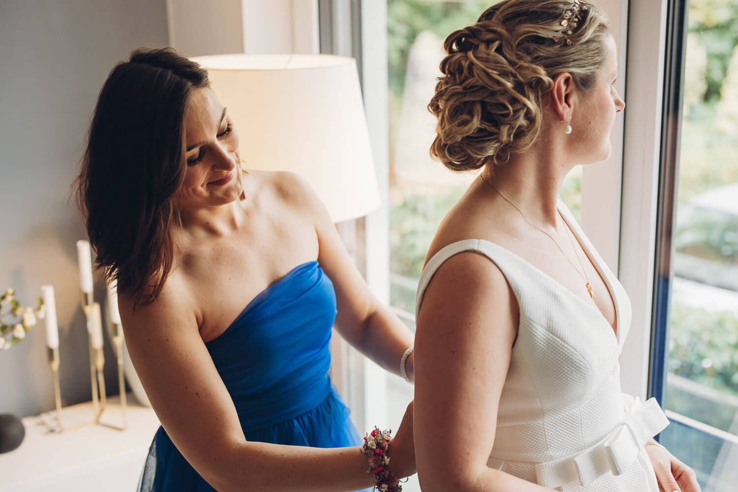 Trauzeugin hilft der Braut beim Ankleiden vor der Hochzeit in Langenhagen