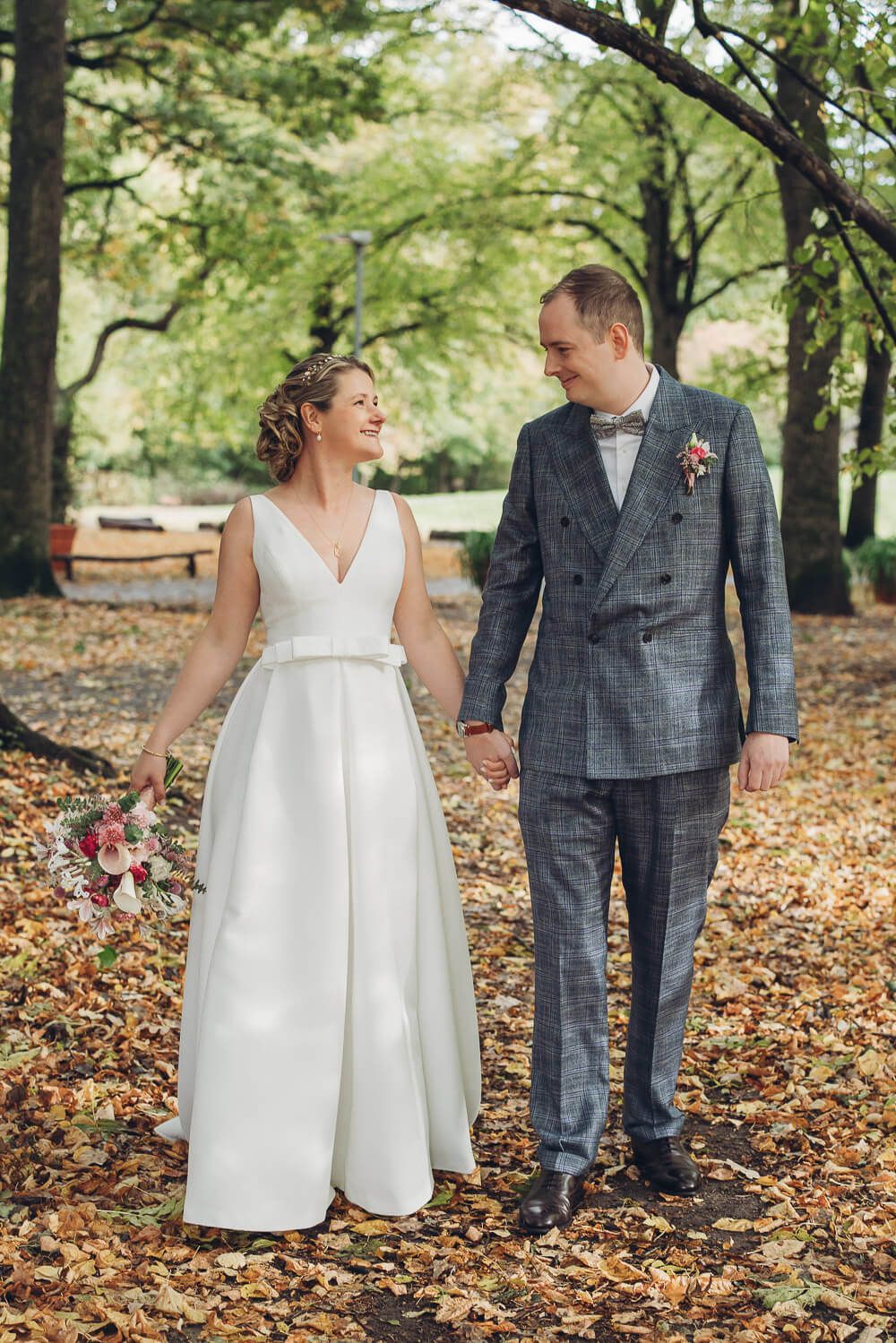 Brautpaar spaziert lachend durch den Park bei einer Hochzeit in Hameln - Fotograf
