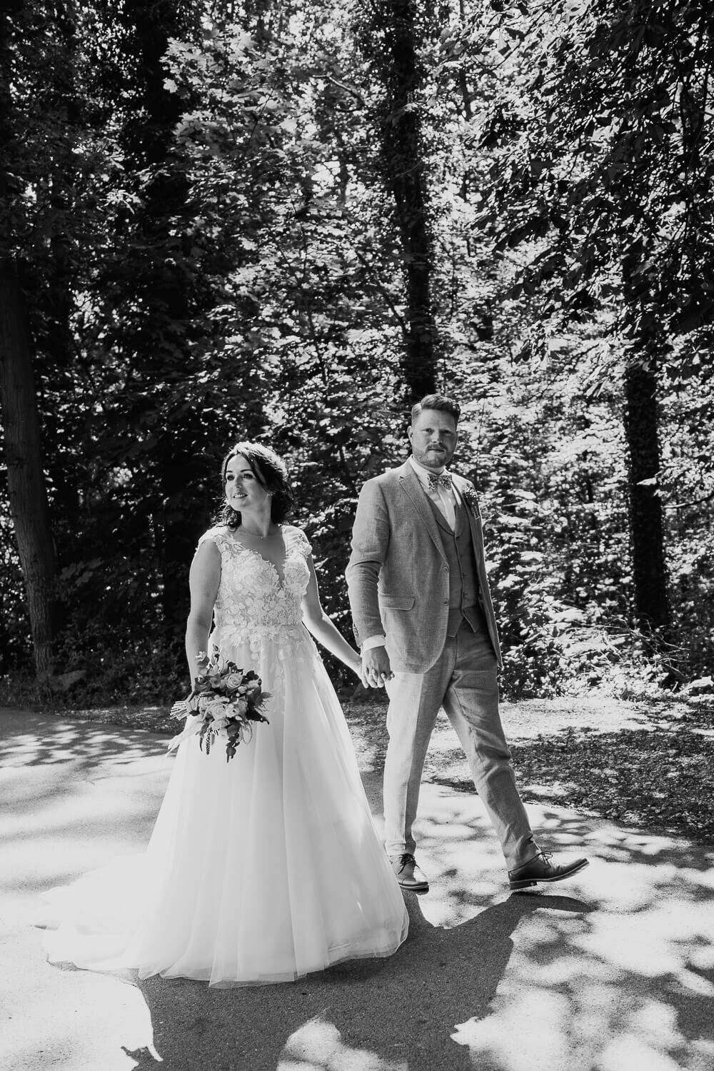Schwarz-Weiß-Aufnahme eines Brautpaares beim gemeinsamen Spaziergang während des Hochzeitsshootings - Hochzeitsfotografin aus Hameln