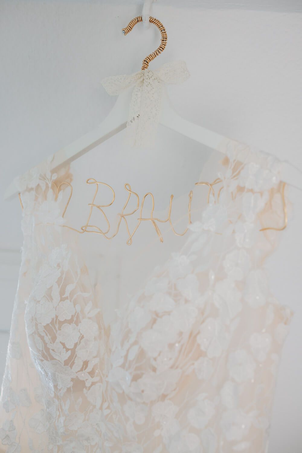 Detailaufnahme eines Brautkleids auf einem personalisierten Bügel mit Schriftzug als eleganter Start in eine freie Trauung in Hannover