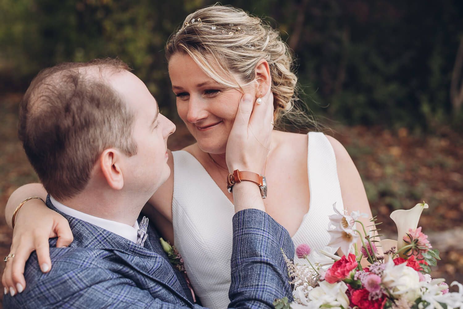 Liebevolles Brautpaarportrait mit zarter Berührung und Brautstrauß bei einem romantischen Hochzeitsshooting in Braunschweig