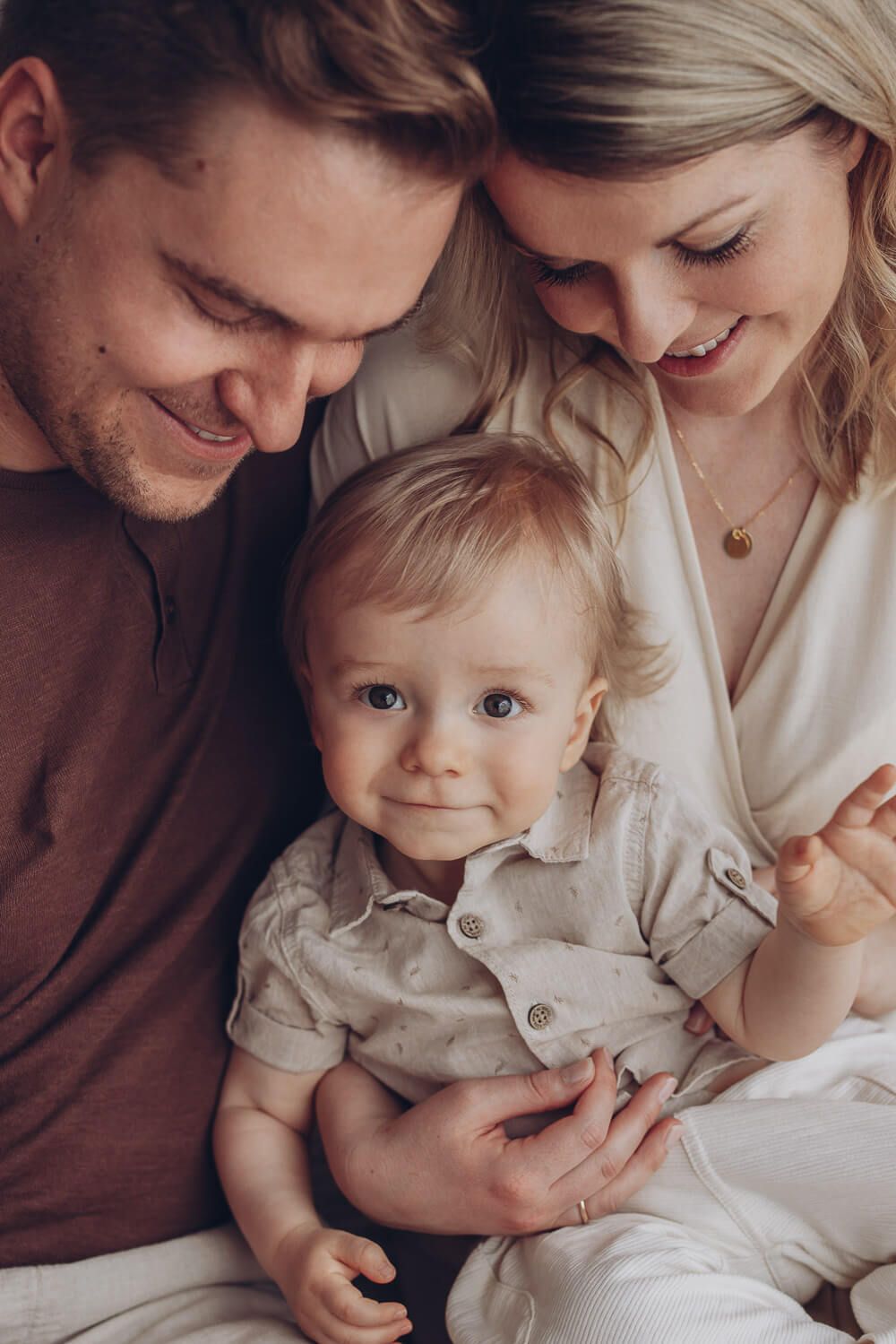Natürliches Familienfoto in Hildesheim – Eltern schauen liebevoll auf ihr Baby beim entspannten Fotoshooting