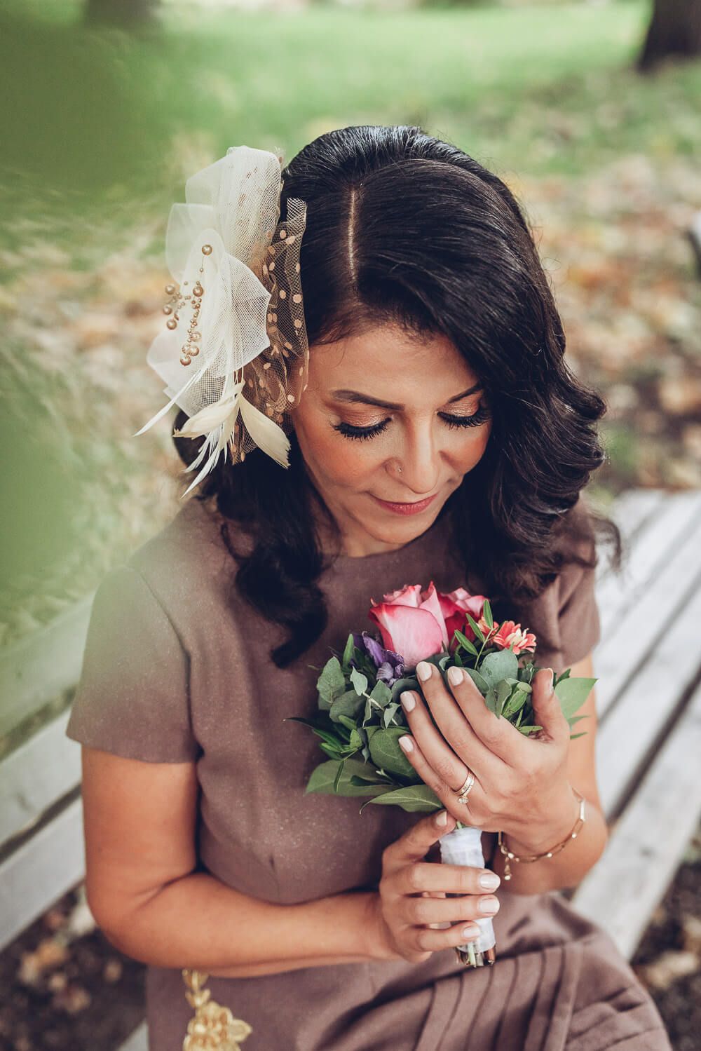 Ruhiges Portrait einer Frau mit Blumenstrauß und auffälligem Vintage-Haarschmuck, fotografiert von einem Hochzeitsfotografen in Celle