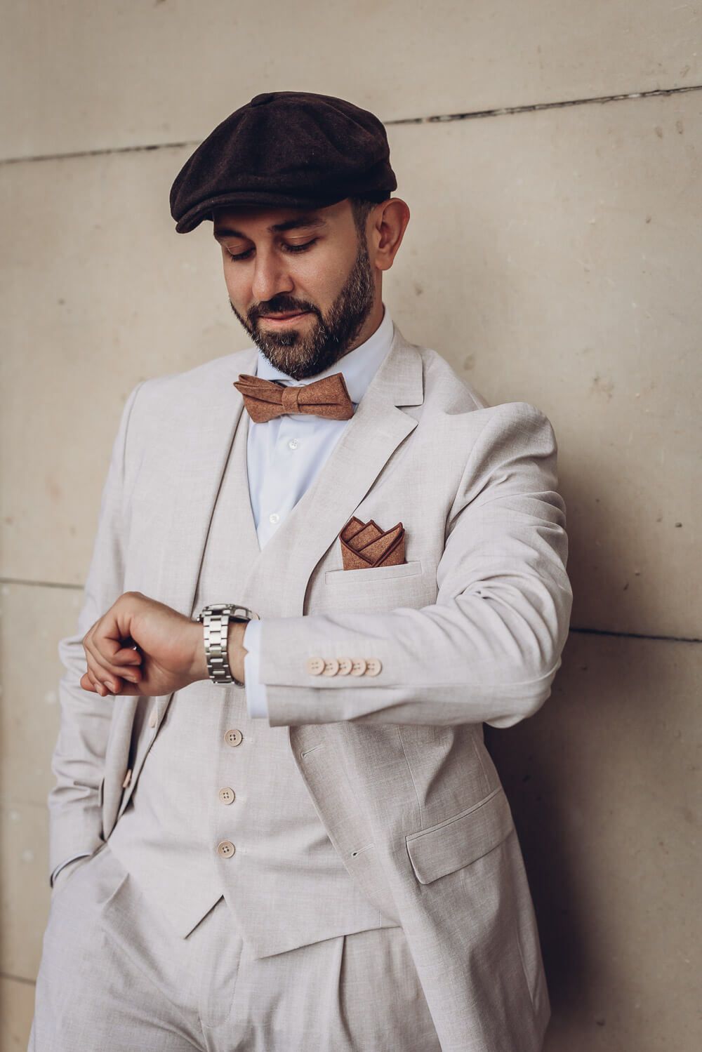 Elegantes Portrait eines Bräutigams, der auf seine Uhr schaut, fotografiert von einem Fotografen in Braunschweig