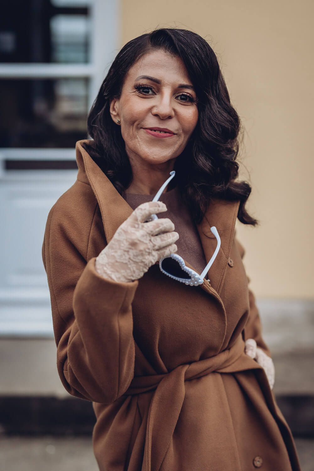 Stilvolles Portrait einer Frau, die eine auffällige Sonnenbrille in der Hand hält, fotografiert von einer Fotografin in Langenhagen