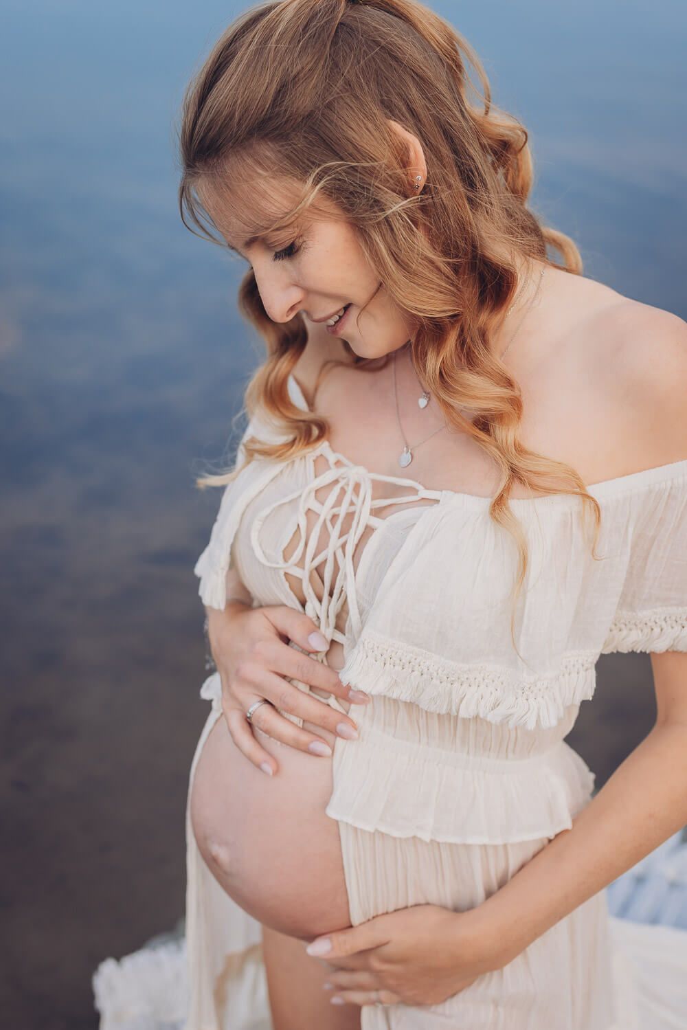 Nahaufnahme beim Babybauch Fotoshooting am See in Neustadt am Rübenberge – werdende Mutter hält liebevoll ihren Bauch
