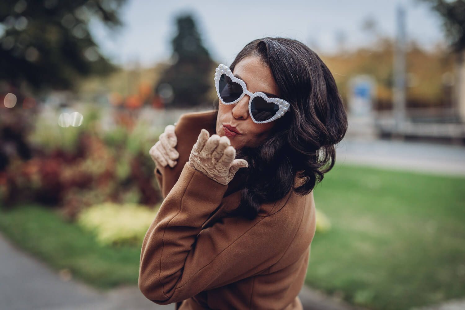 Portrait einer Frau mit auffälliger Herzsonnenbrille und Spitzenhandschuhen, aufgenommen von einer Hochzeitsfotografin in Hannover