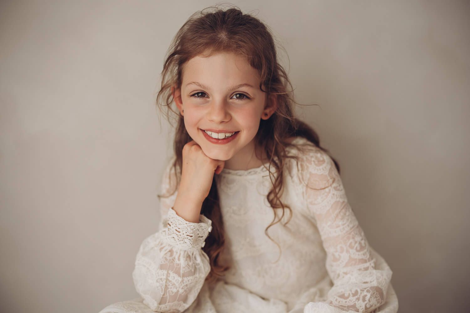 Natürliches Kinderportrait im Fotostudio Hannover mit einem lächelnden Mädchen in heller Kleidung