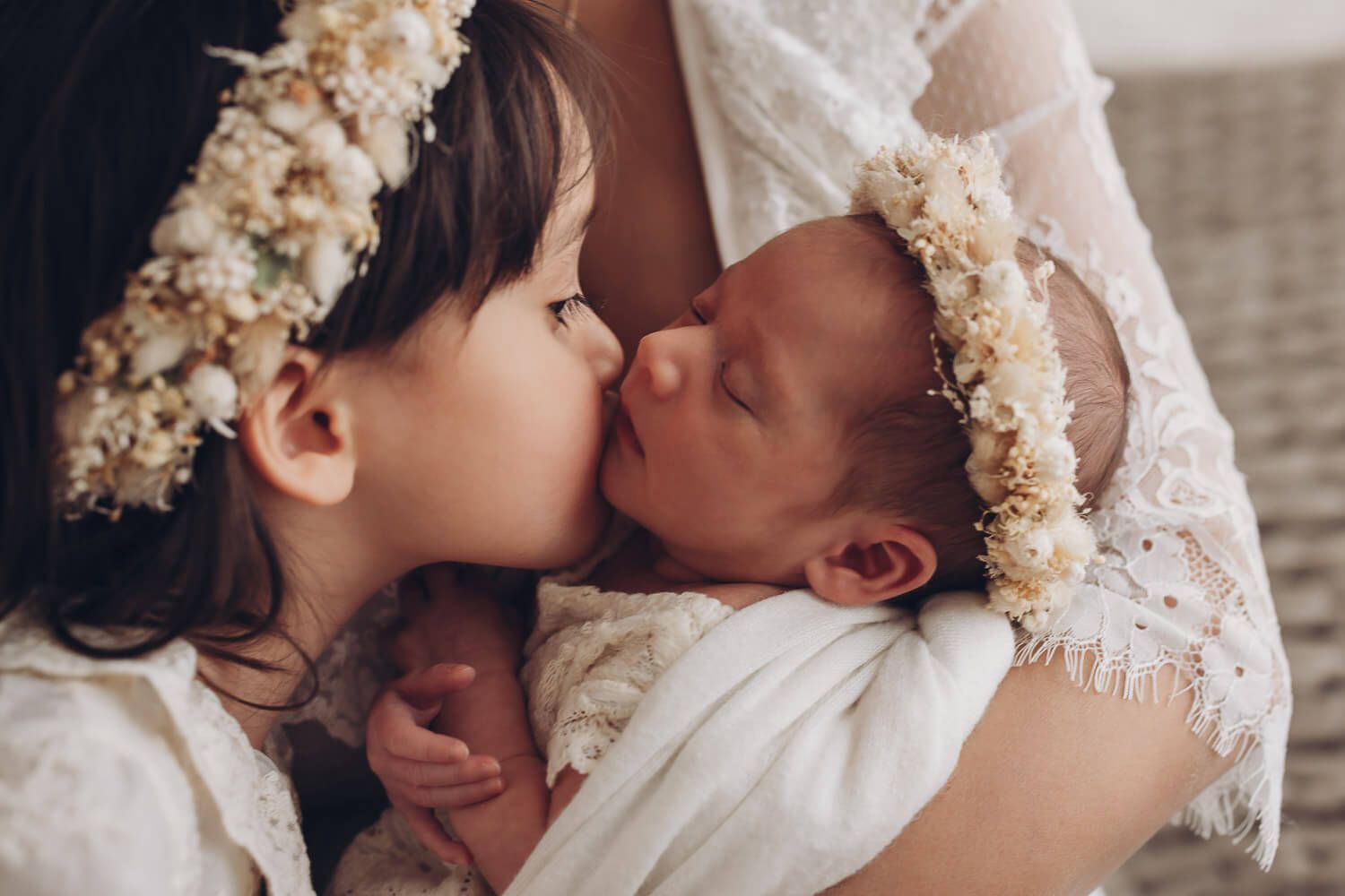 Zärtlicher Moment beim Newborn Shooting in Celle – große Schwester gibt ihrem neugeborenen Geschwister einen liebevollen Kuss