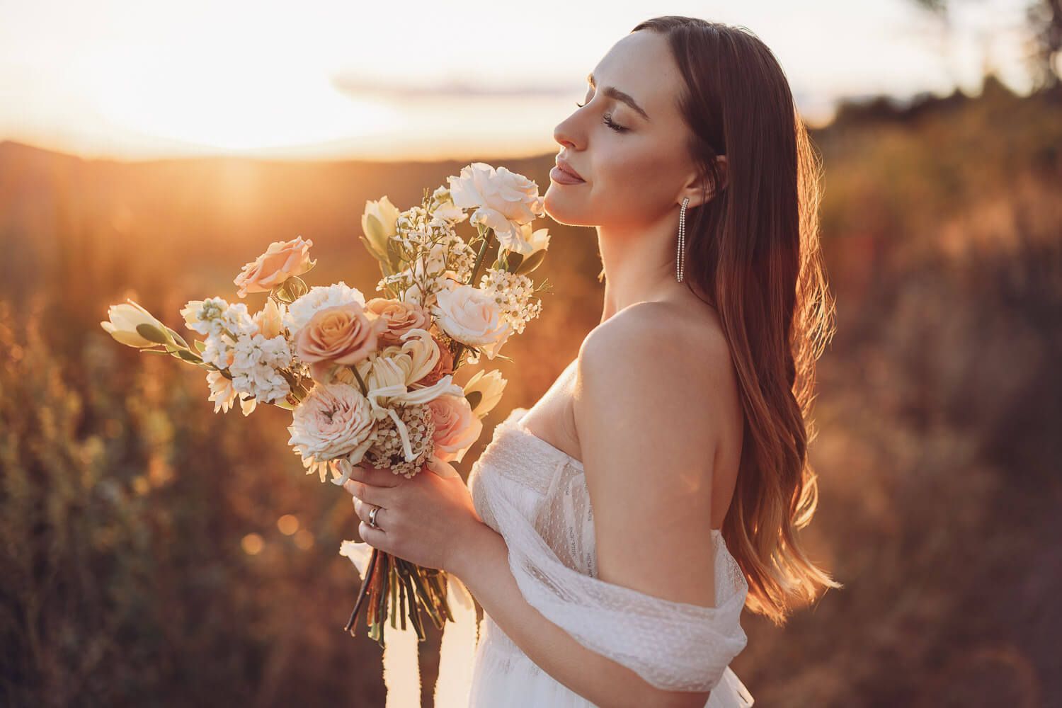 Strahlendes Brautportrait mit Blumenstrauß im goldenen Sonnenlicht bei einem Hochzeitsshooting in Langenhagen und Hannover