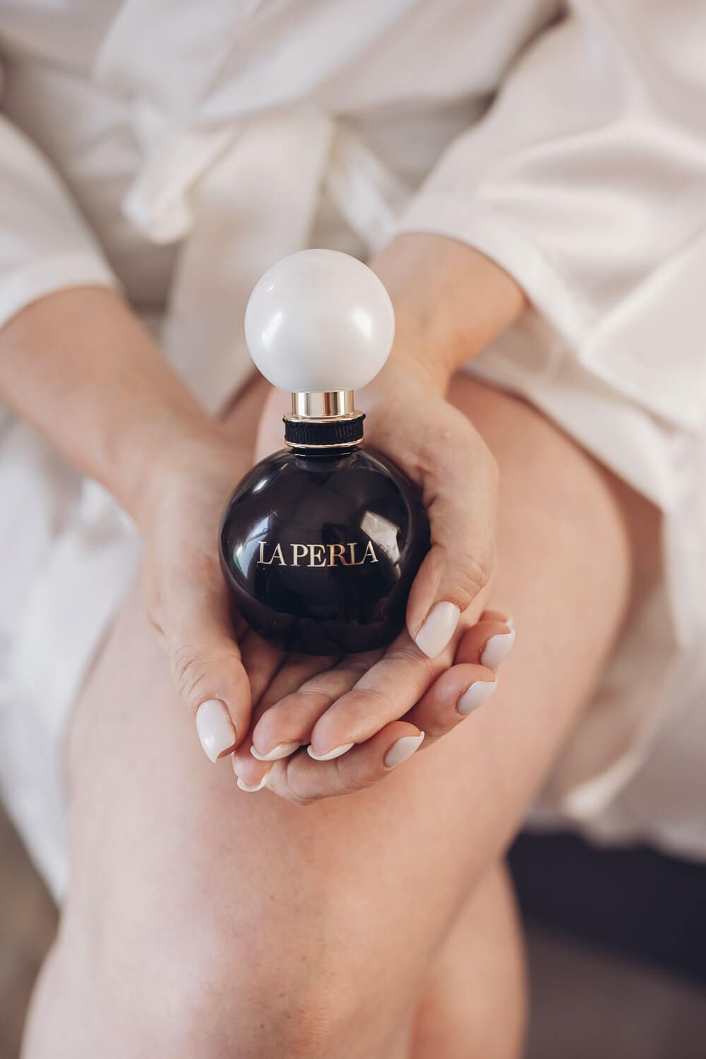 Detailaufnahme eines Parfums in den Händen der Braut beim Getting Ready - Hochzeitsreportage Fotograf in Peine, Pattensen und Hameln
