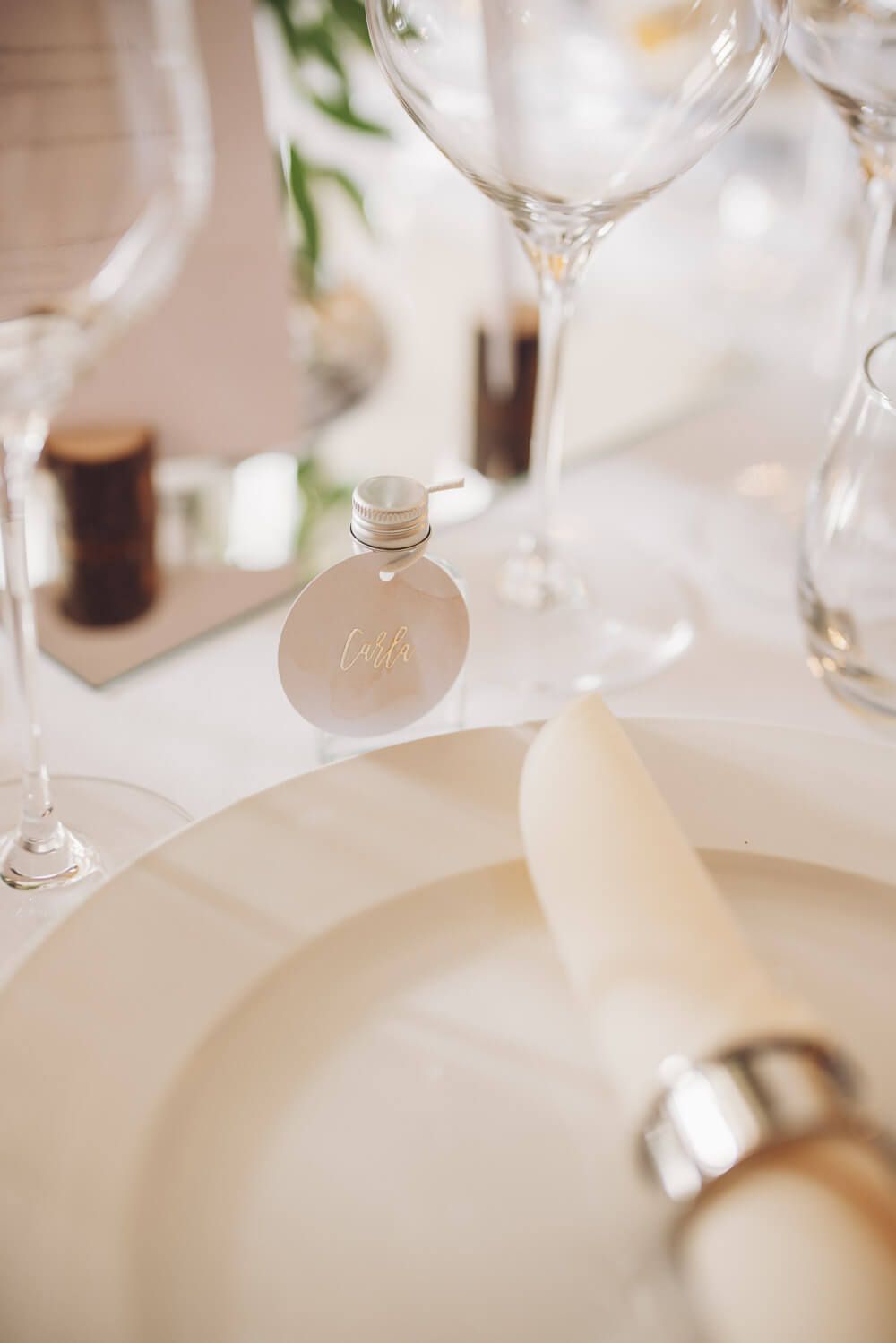 Feine Tischdetails einer Hochzeit mit Platzkärtchen, Glasdekoration und cremefarbener Serviette - Hochzeitsfotograf Pattensen