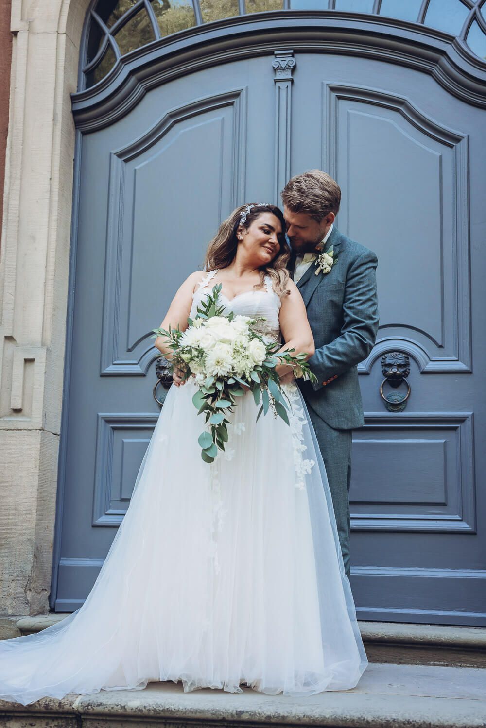 Brautpaar vor einer stilvollen historischen Tür beim romantischen Hochzeitsportrait, fotografiert von einer Fotografin in Langenhagen