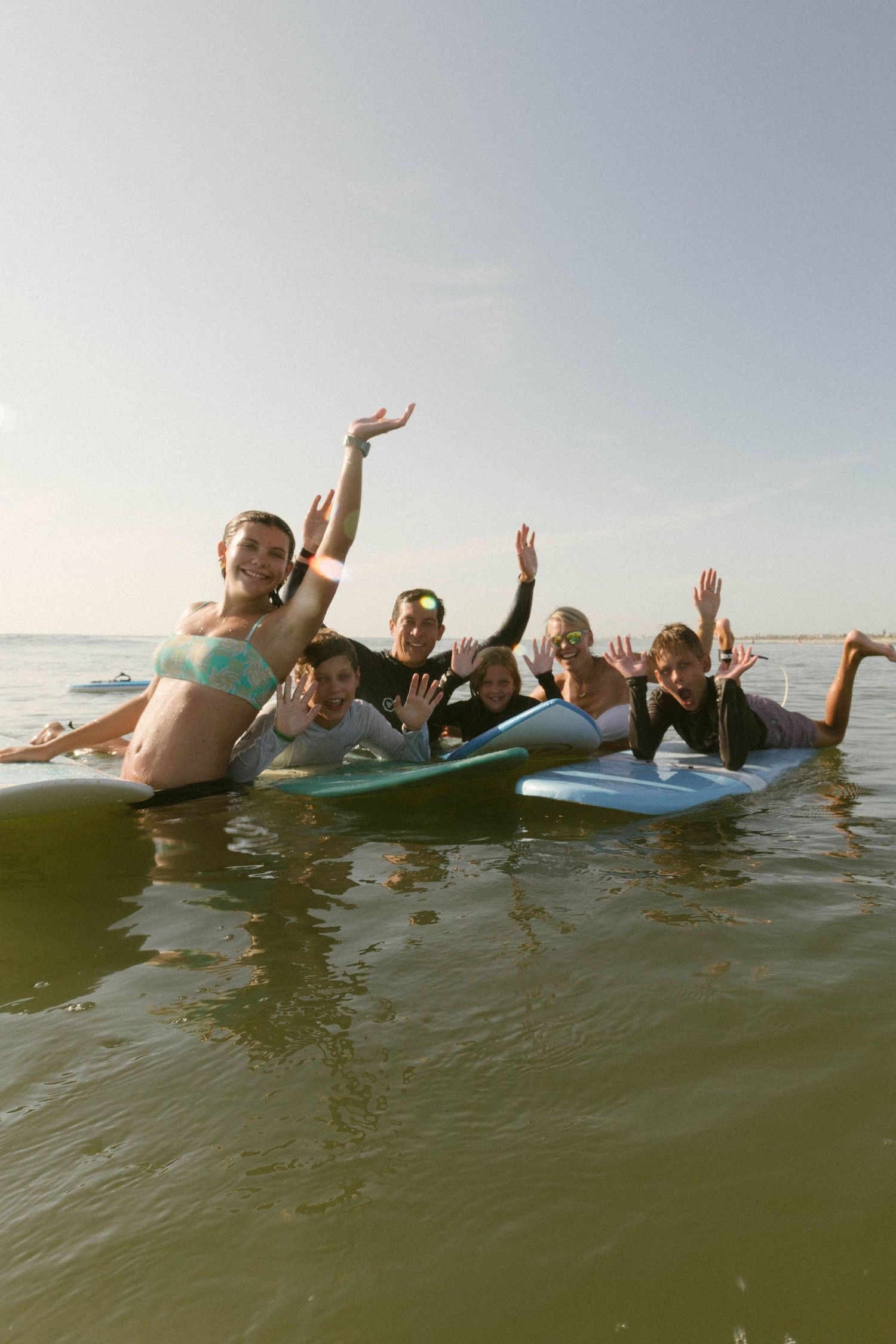 A sequence of photos showing people floating and waving while relaxing in ocean water on a sunny day.