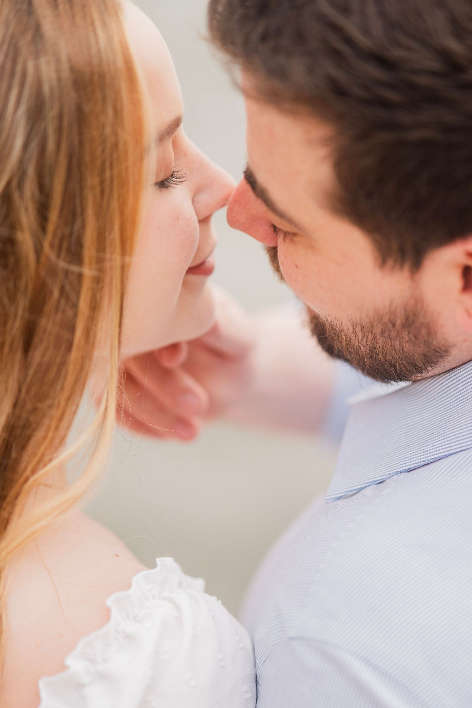 Close-up of couple sharing a tender almost-kiss during romantic engagement session.