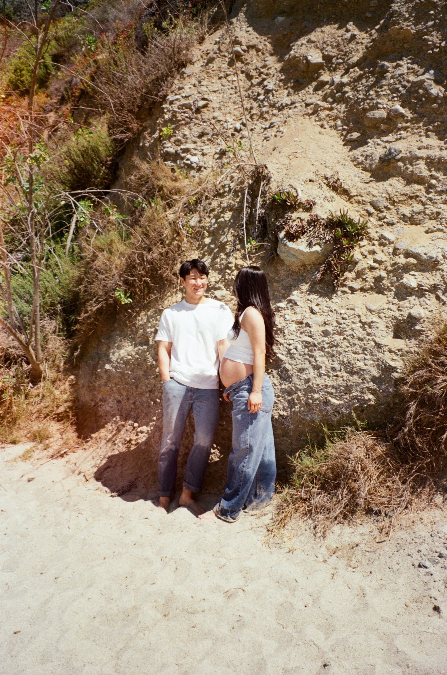 A sequence of photos showing two people sitting on a sandy slope against a rocky cliff wall in natural lighting.