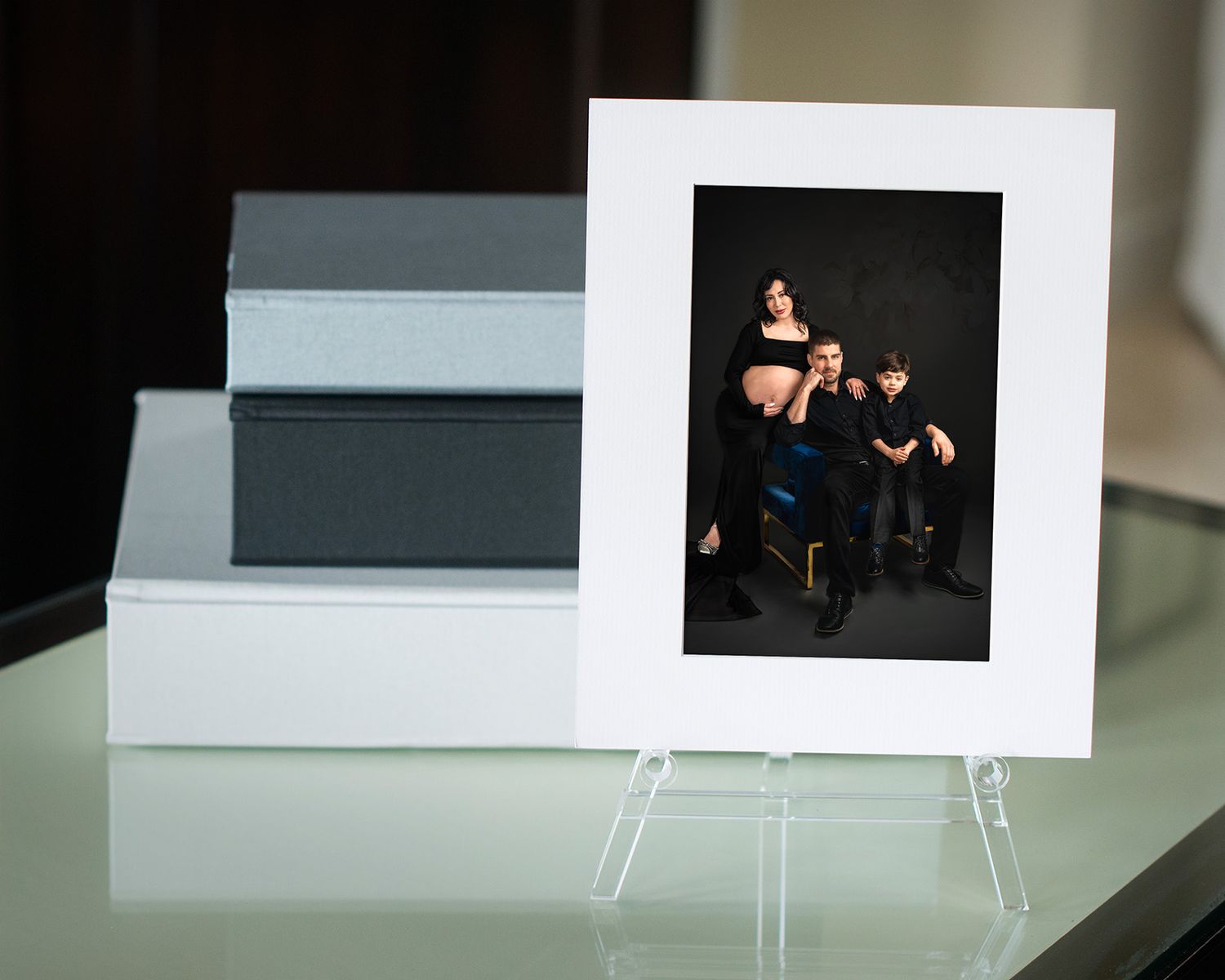 A row of white photographs displayed on easels against a dark background in a gallery setting.