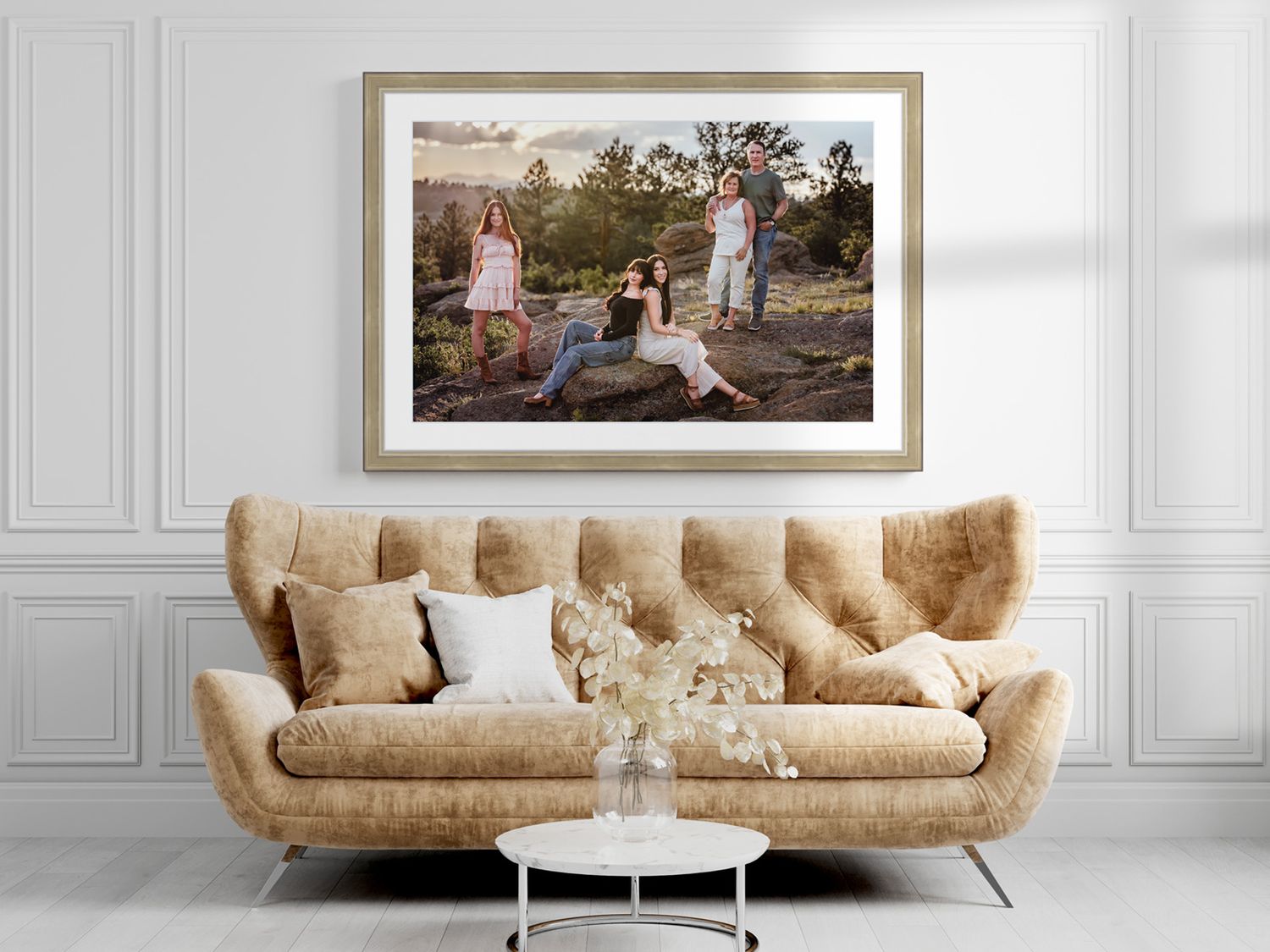 Framed outdoor family portrait displayed above a velvet sofa, photographed by a Denver maternity photographer.