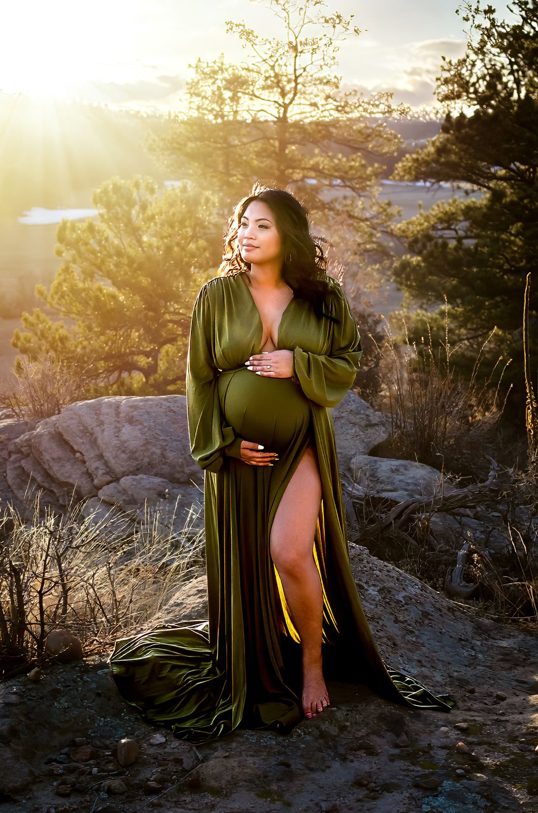 Sunset maternity portrait in Denver featuring pregnant woman in green gown captured outdoors by luxury maternity photographer.
