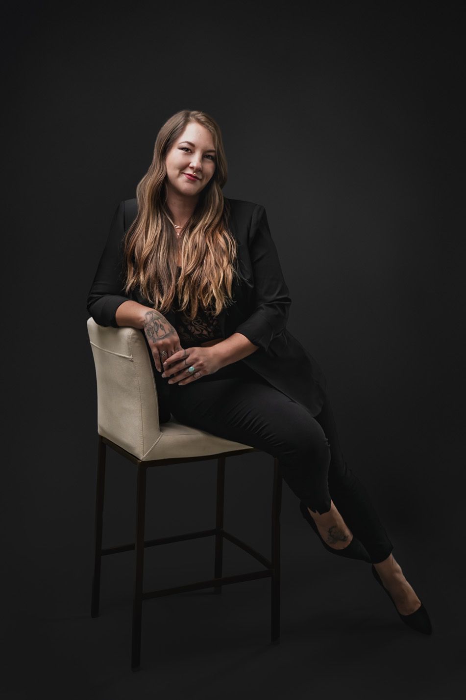 Portrait of Amanda Wyman, Denver maternity and birth photographer, seated in a modern studio setting for her About Me page