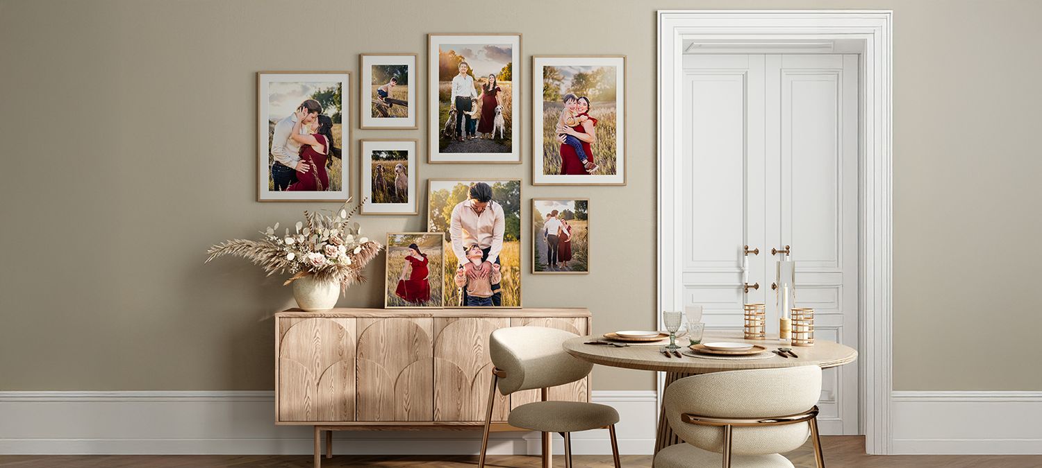 Gallery wall of framed family portraits above rustic wooden console table with modern decor in neutral living room setting.