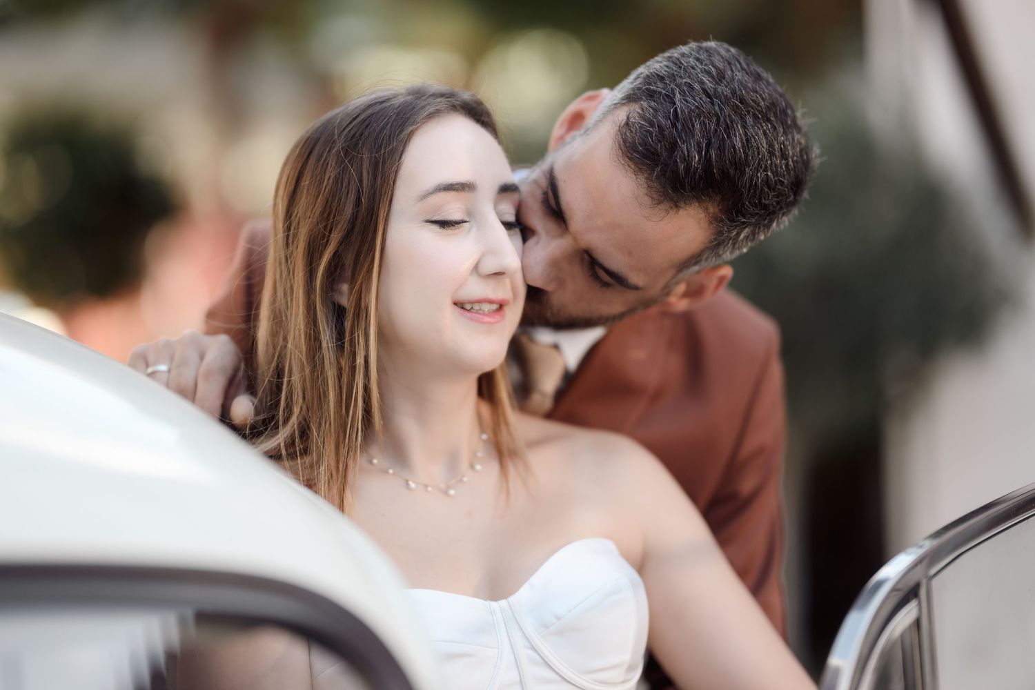 A romantic moment between a couple outdoors with soft natural lighting.