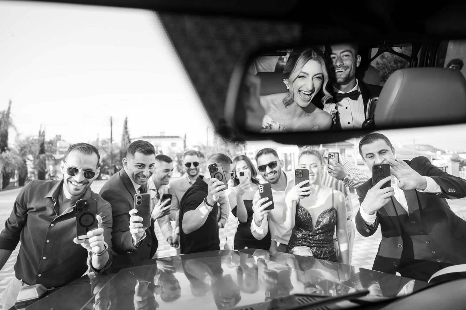 Wedding party posed for photos holding up their drinks in a celebratory toast sequence.