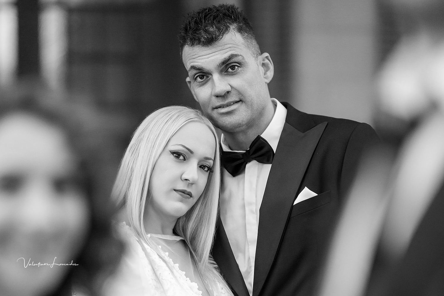 Black and white formal wedding portrait showing couple in elegant attire.