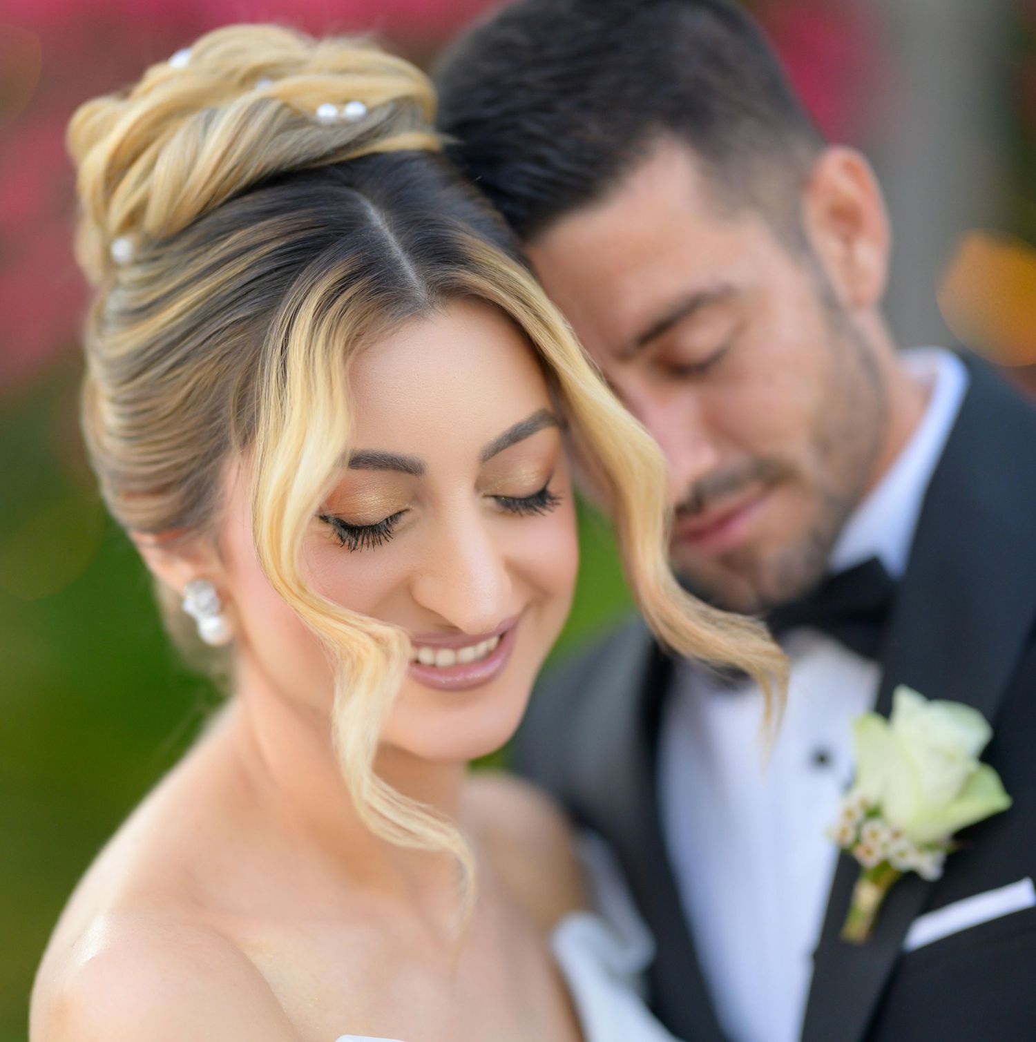A romantic close-up of a bride and groom sharing an intimate moment during their outdoor wedding celebration.