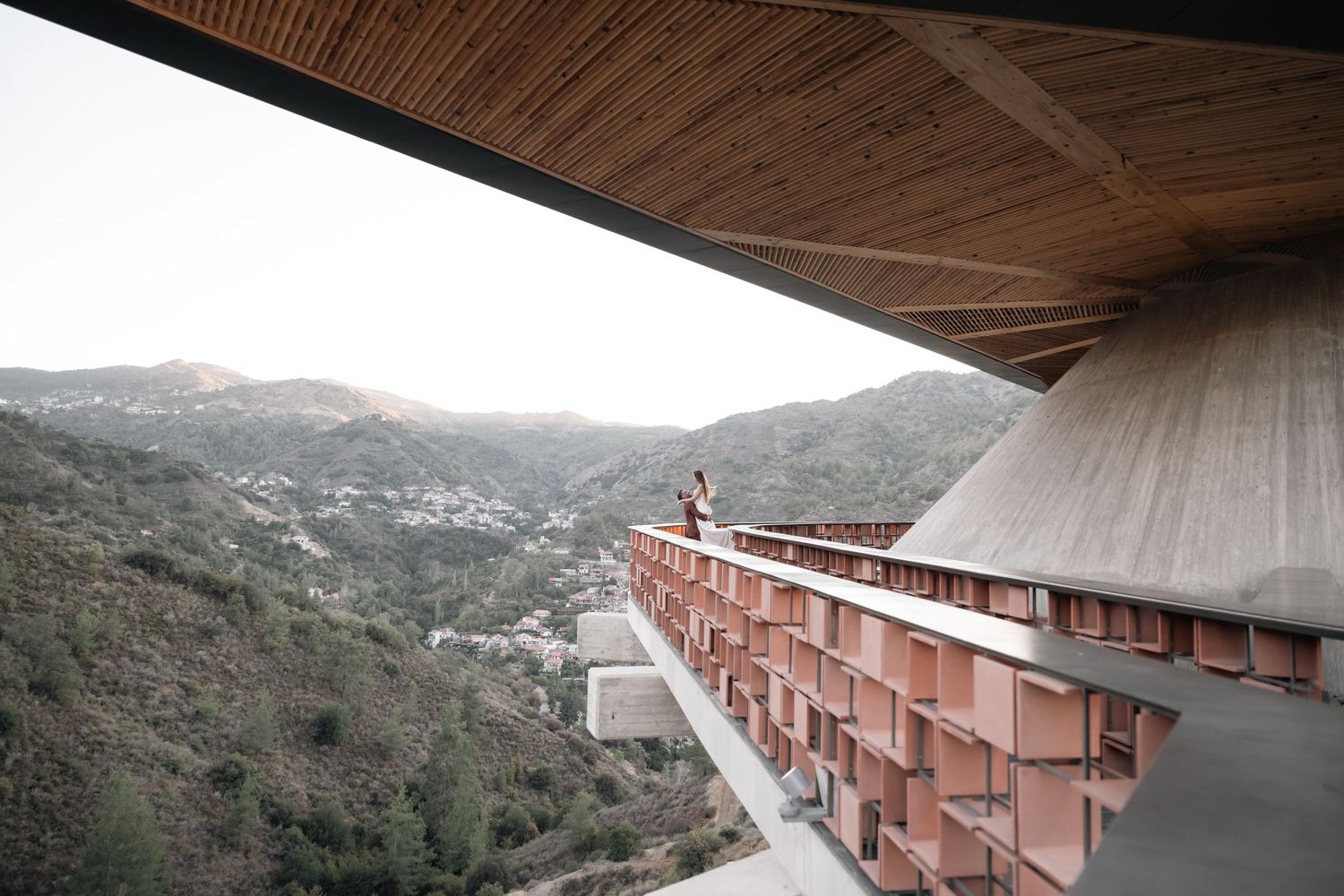 Modern architectural structure with mountain views and unique railing design.
