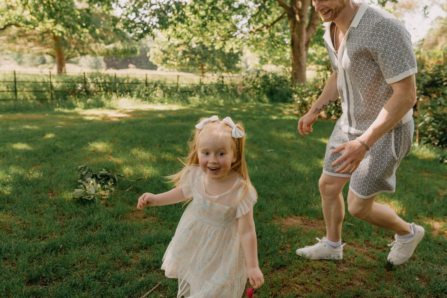dad chasing daughter around during a candid outdoor family photoshoot in Edinburgh