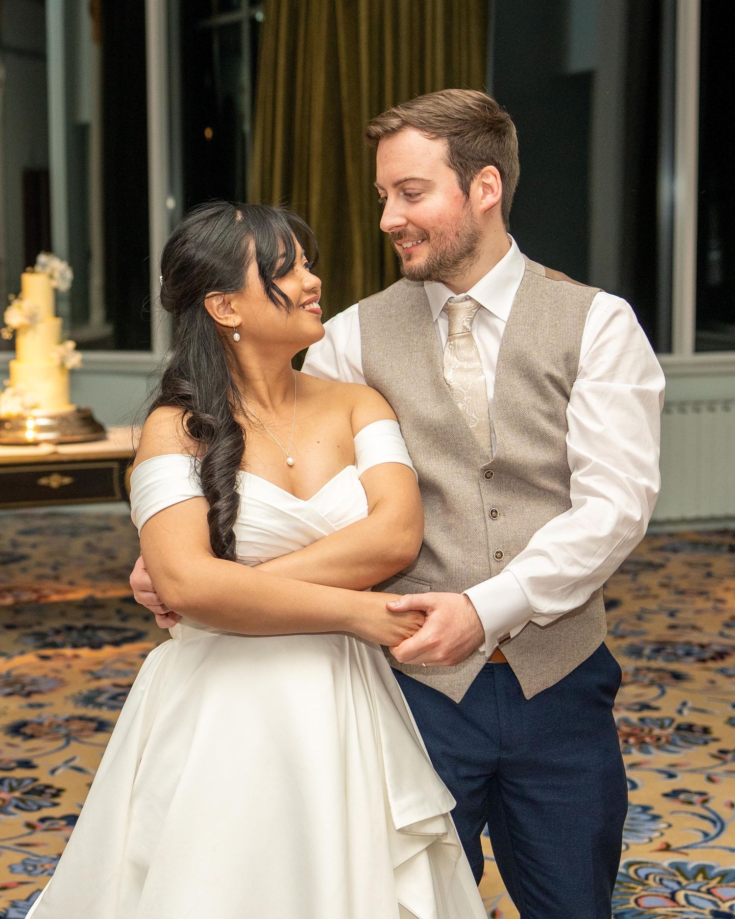 A bride and groom share a romantic moment, smiling at each other during their wedding reception. Dave Martin Weddings Northern ireland