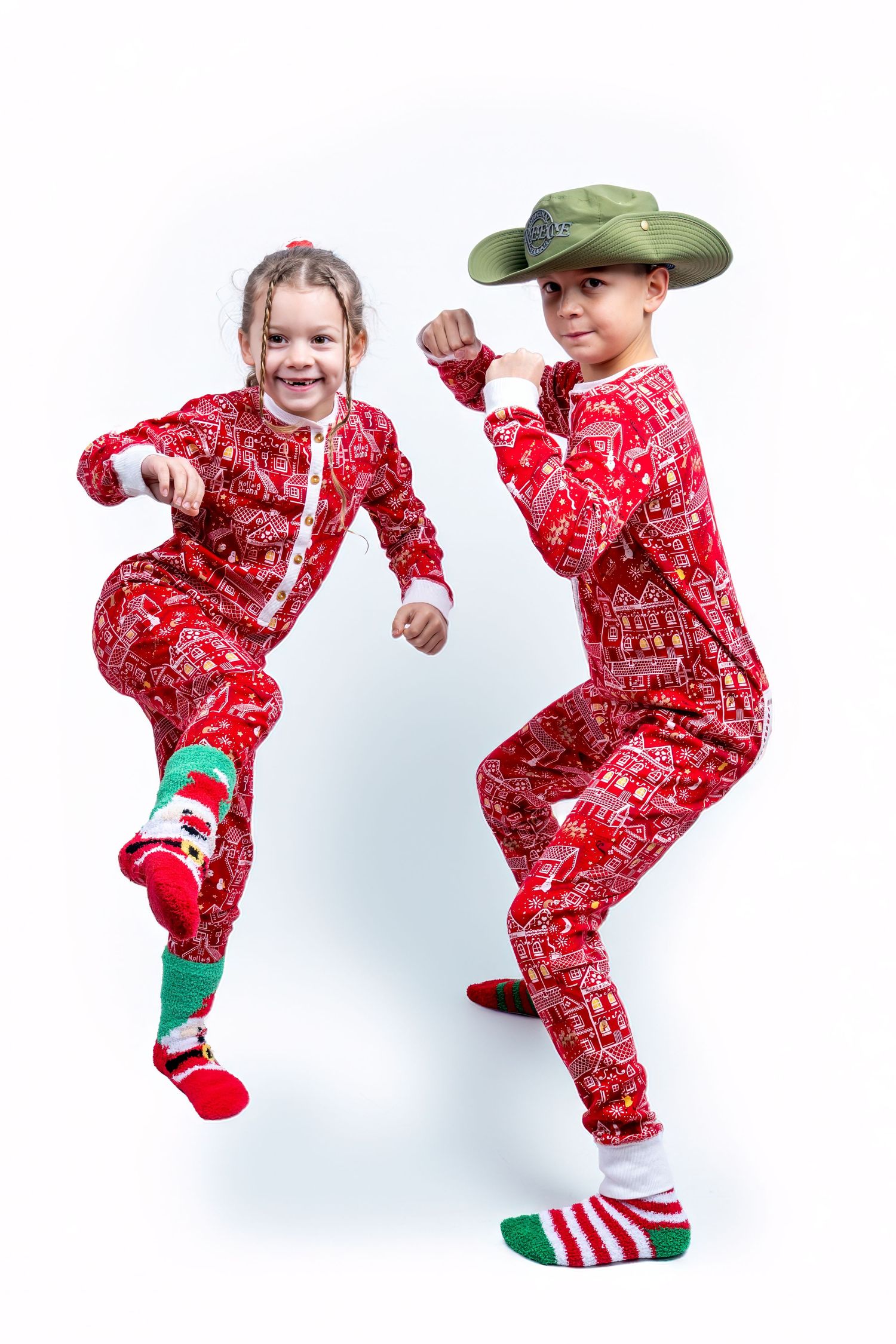 Two children in red Christmas pajamas dancing and posing playfully in studio. Dave Martin Photography Studio Belfast