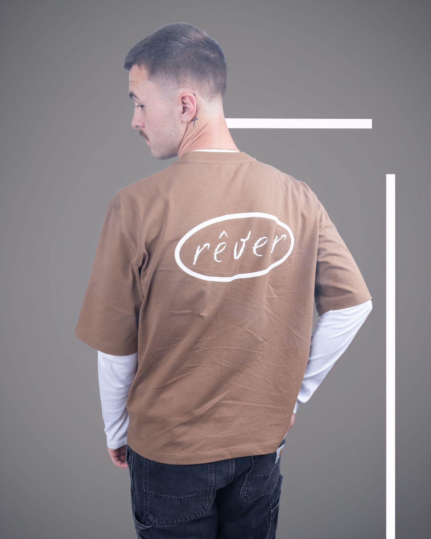 A man wearing an oversized brown Rever brand t-shirt layered over a white long sleeve shirt. Dave Martin Photography Studio Belfast