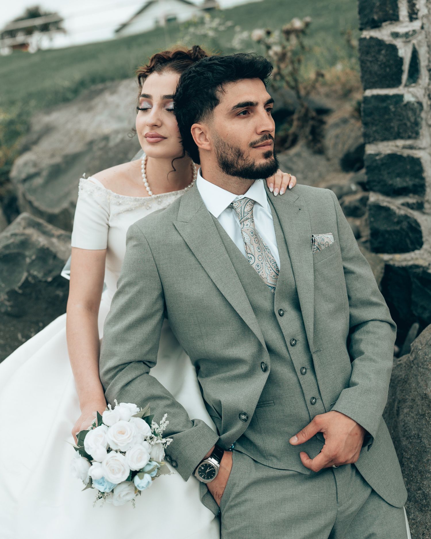 A bride in white gown holding bouquet poses with groom, Dave Martin Northern Ireland Wedding