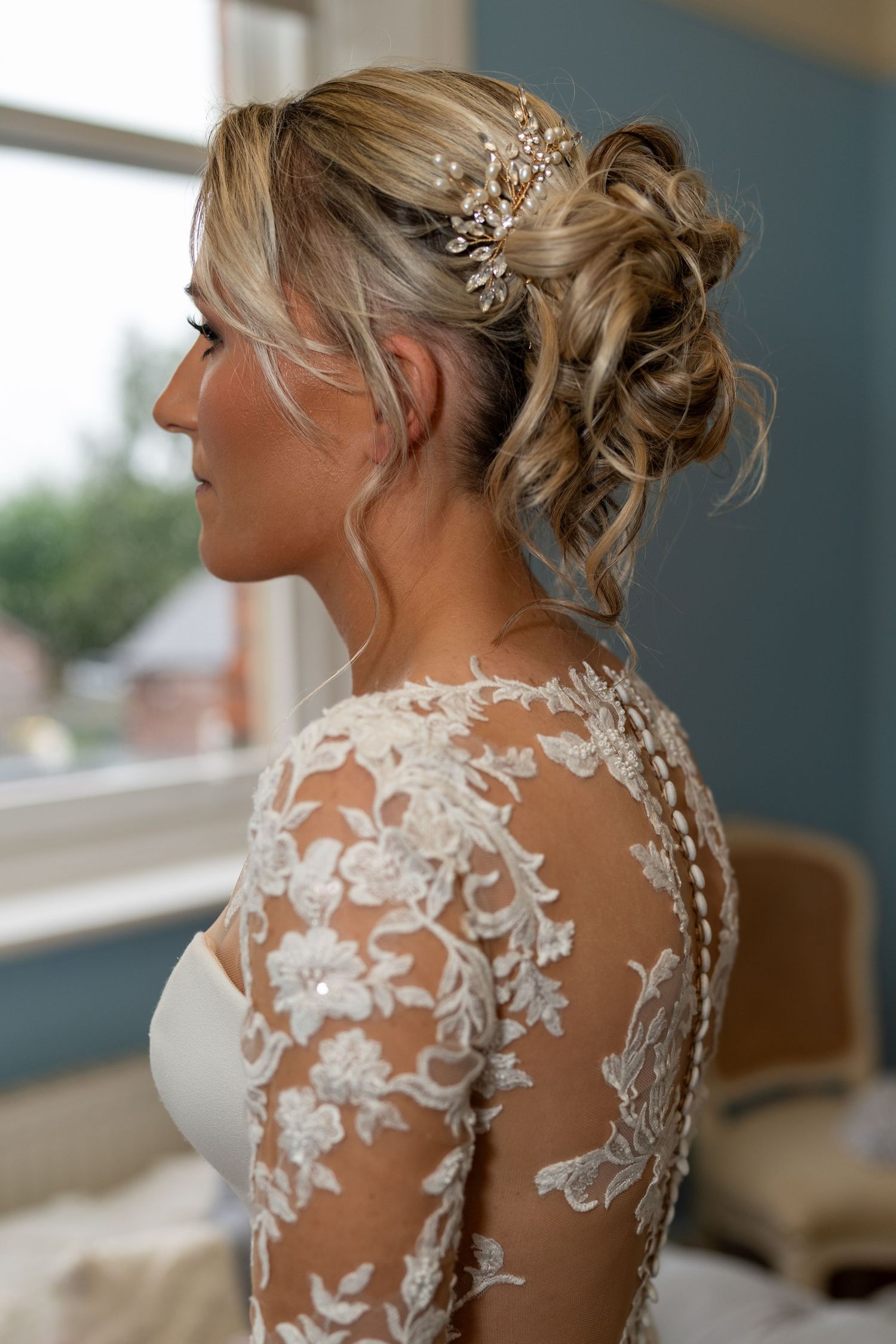 Bride with elegant lace wedding dress and floral hair accessory in a romantic updo hairstyle, photographed by Belfast wedding photographer.