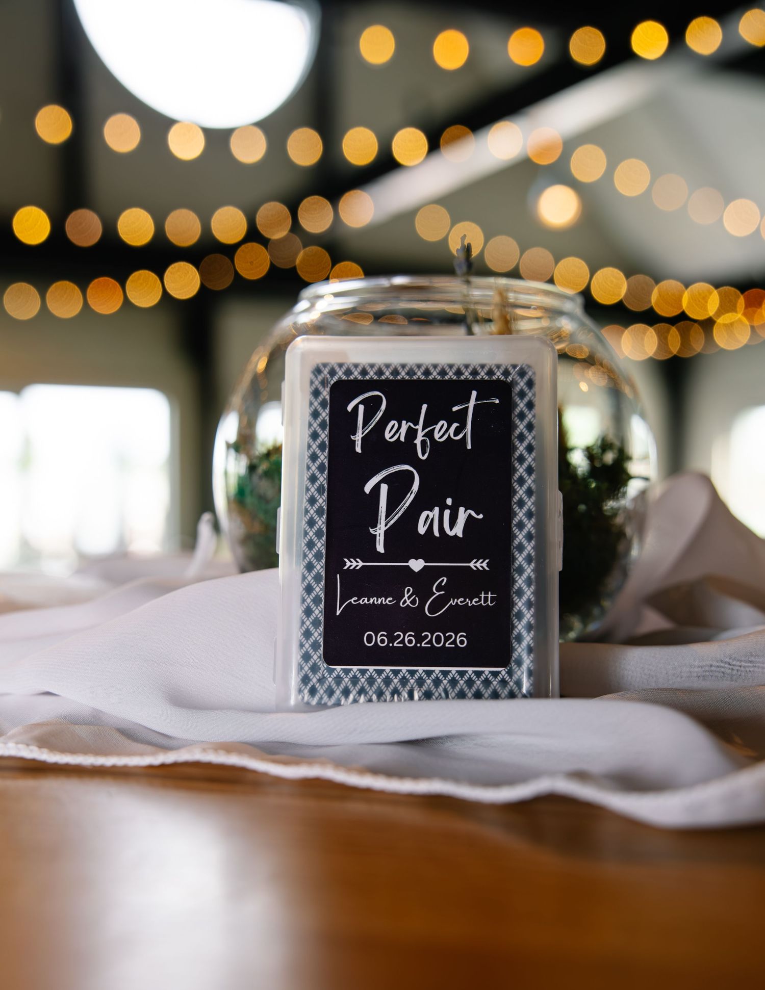 Custom wedding matchbox favor reading Perfect Pair with couple names Leanne and Everett dated 06.26.2026 on table.