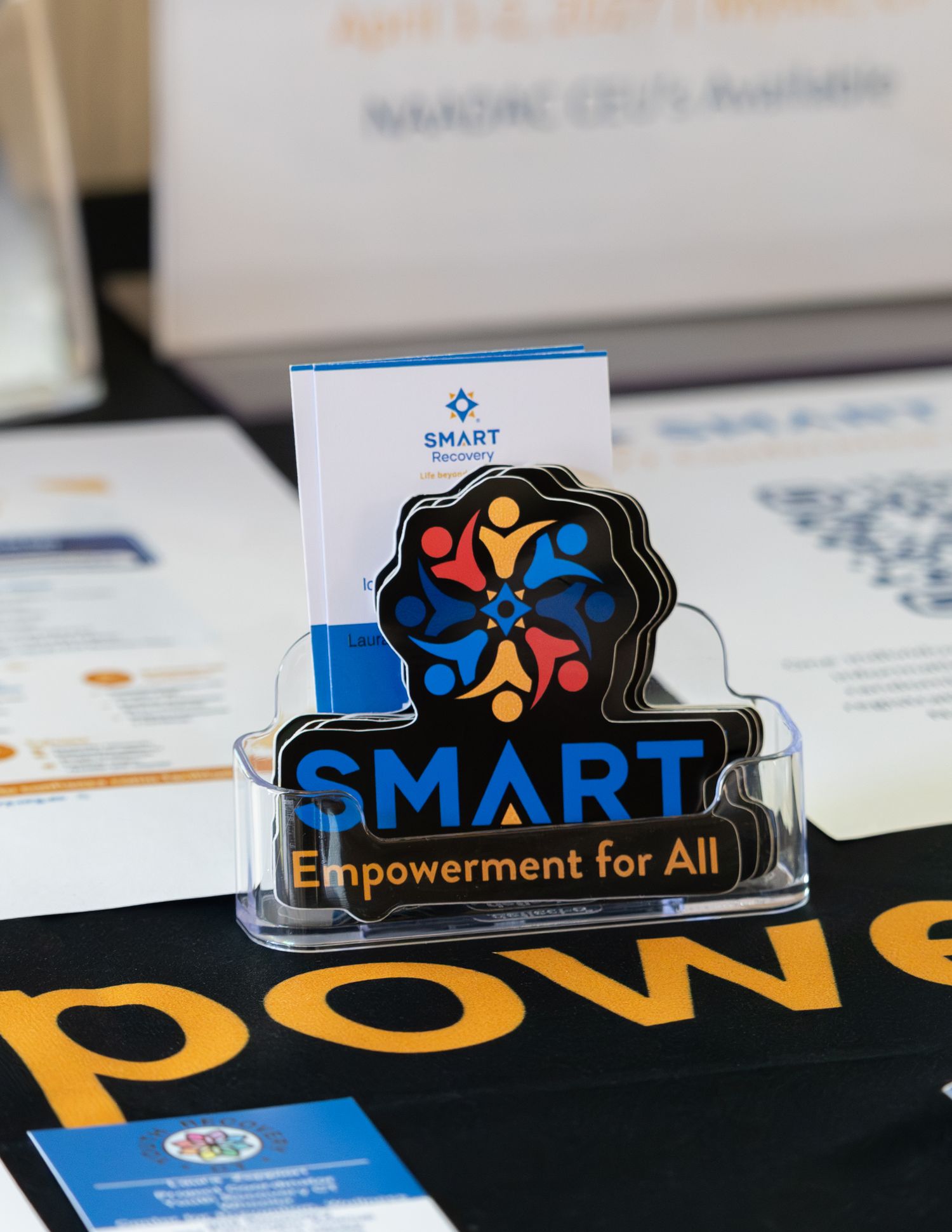SMART Empowerment for All branded display stand with business cards at a conference event.