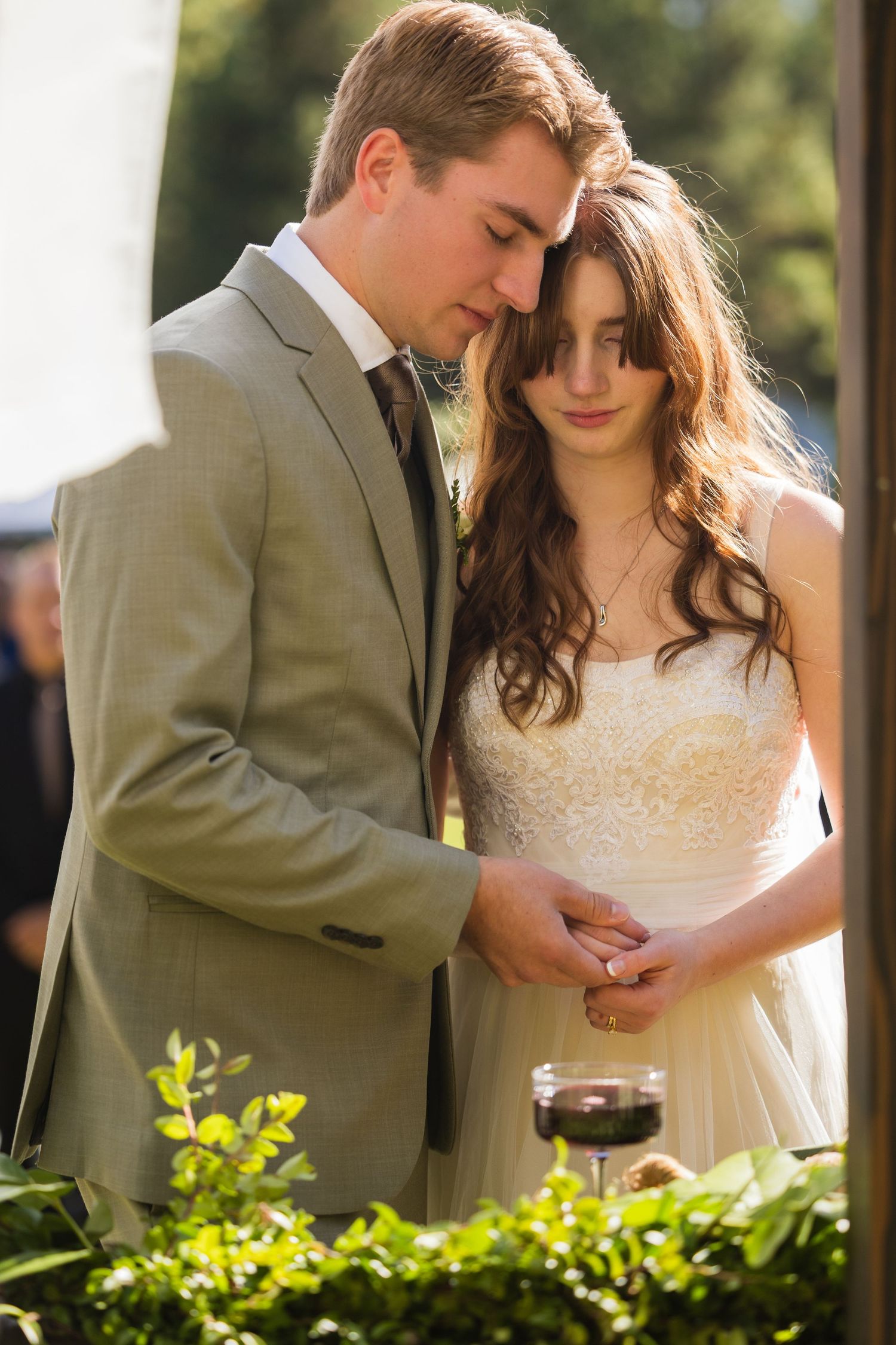 Couple holding hands during outdoor wedding ceremony.