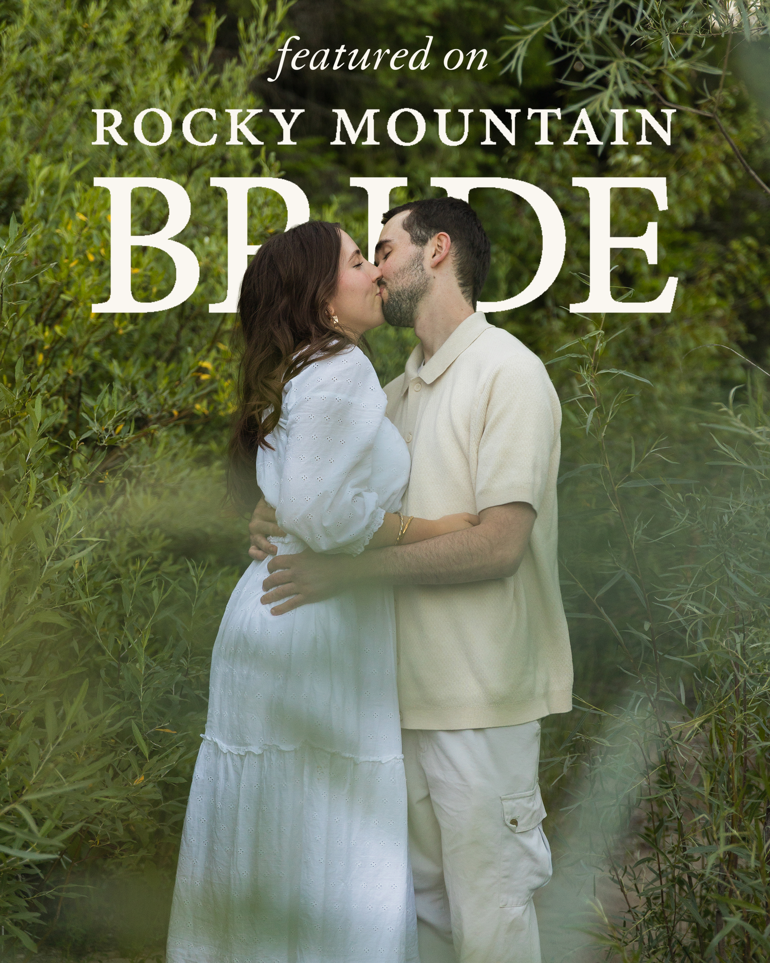 A couple shares a romantic kiss outdoors surrounded by lush greenery, featured on Rocky Mountain Bride magazine.