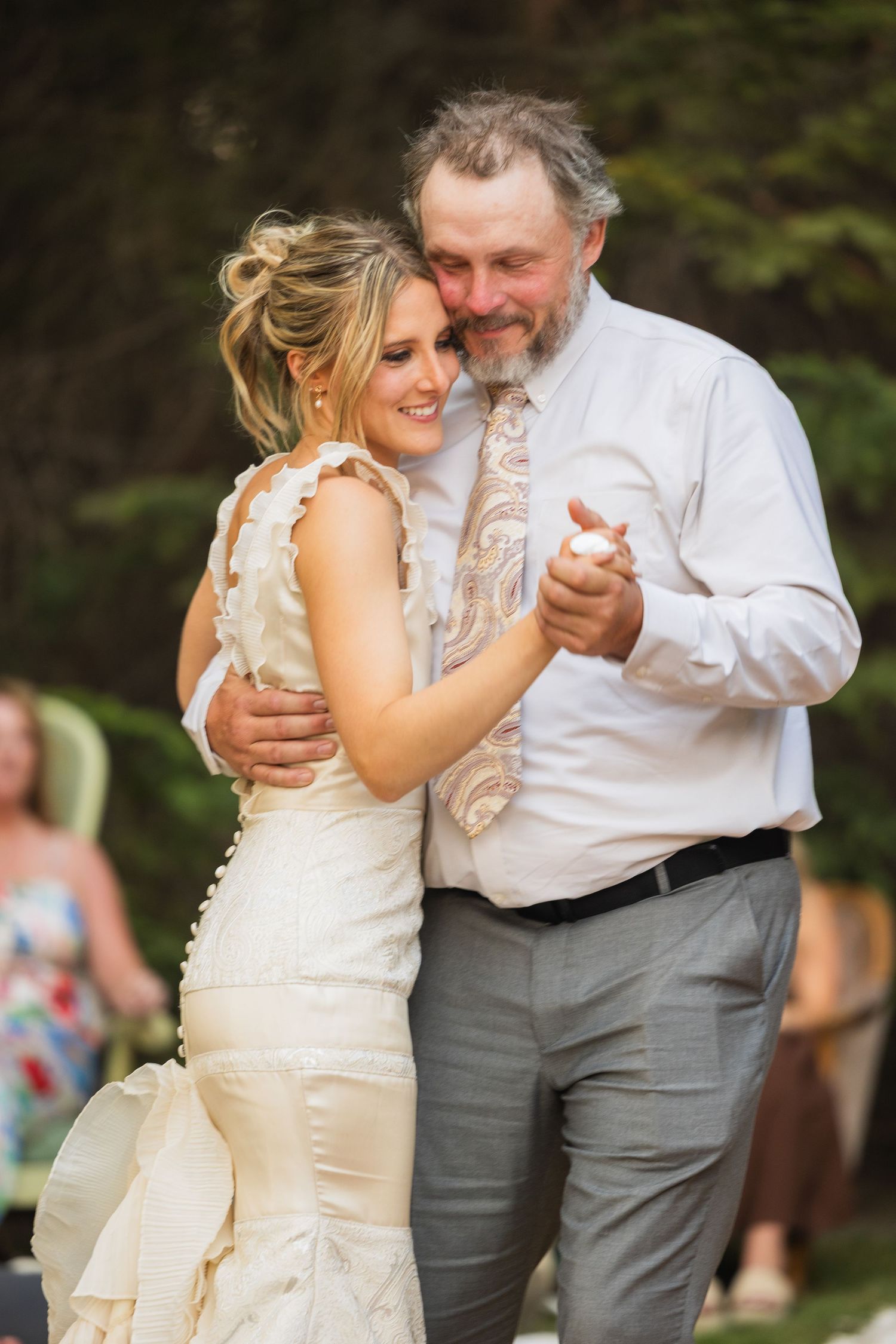 Bride sharing a father-daughter dance at an outdoor wedding reception.