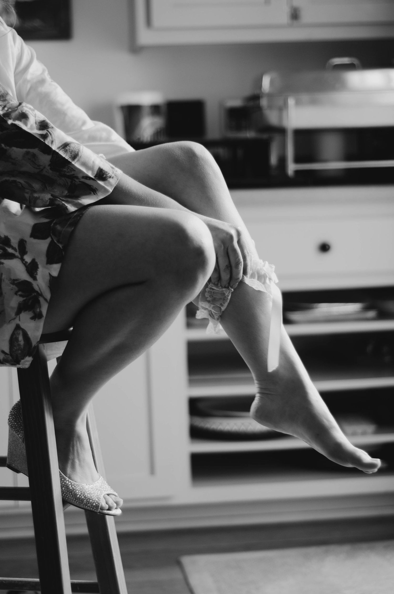 Bride putting on her garter belt while getting ready for her wedding.