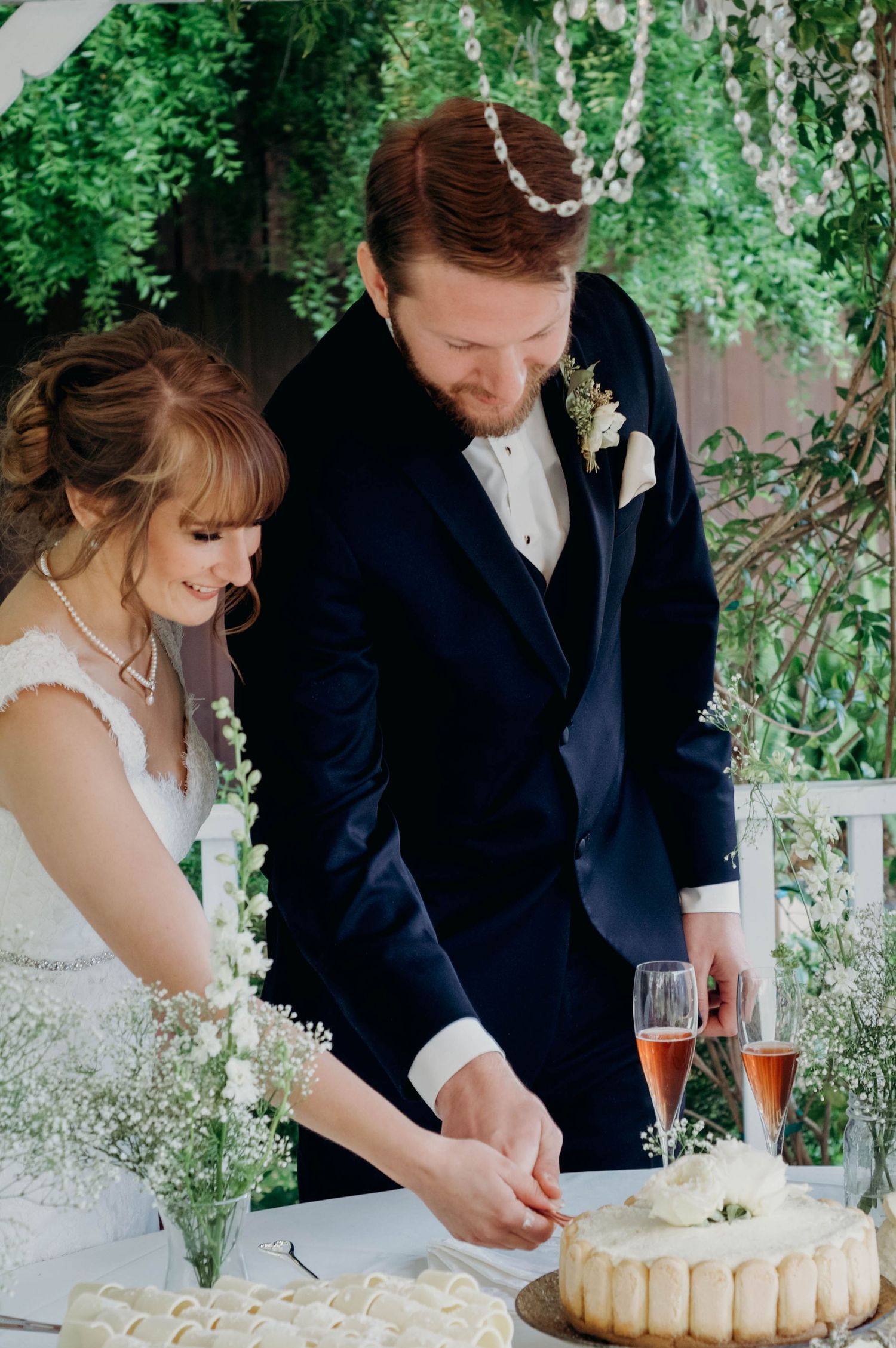 Bride and groom cut their wedding cake together at the reception.