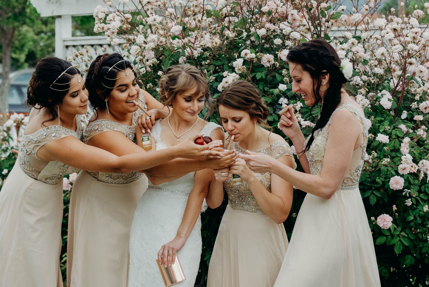Bridal party including bride and bridesmaids smoking cigars before the ceremony.