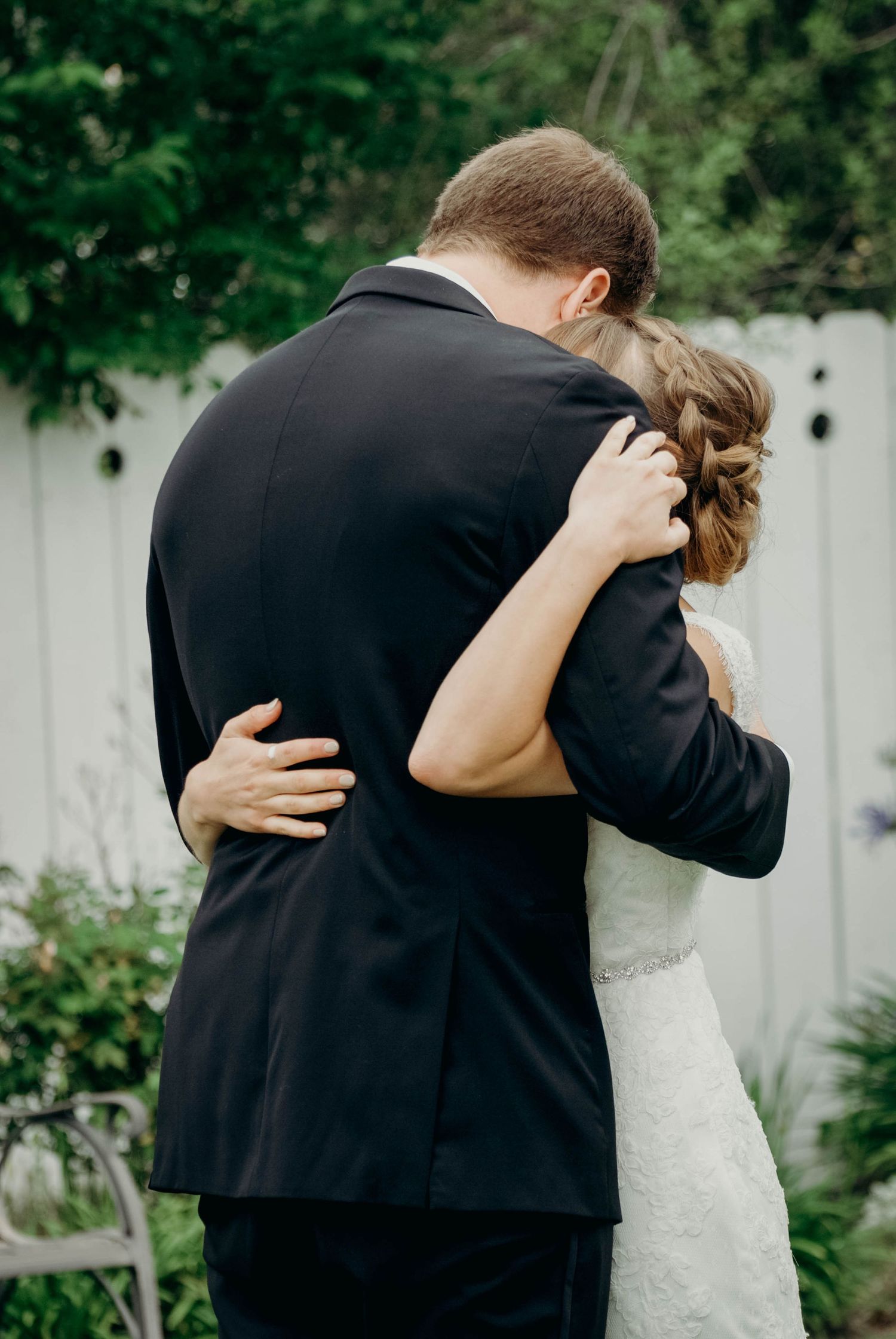 Bride and groom embrace, having a quiet moment together during their first look just before the ceremony.
